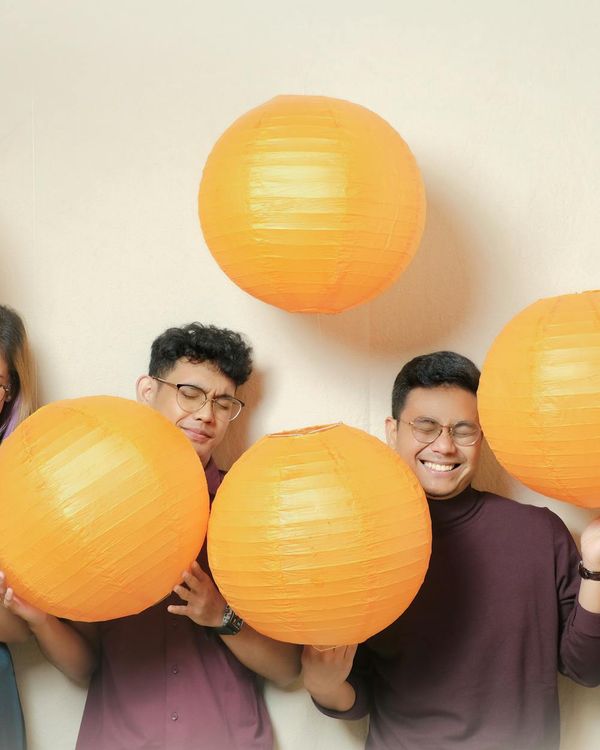 Diverse group of people smiling during a light yoga session in a bright studio.